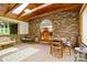 Cozy sunroom with brick walls, wooden accents, and rustic furniture, creating a warm and inviting space at 332 York Spann Rd, Hamptonville, NC 27020