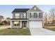 Charming two-story home with a gray exterior, stone accents, a covered porch, and an attached two-car garage at 3888 12Th Ne St, Hickory, NC 28601