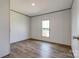 Bright bedroom with a window, wood-look flooring, and neutral walls ready for personal touches at 445 Davis Rd, Shelby, NC 28152