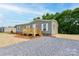 View of the home with charming porch and landscaping, set on a gravel lot at 445 Davis Rd, Shelby, NC 28152