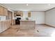 Bright kitchen featuring a center island, modern appliances, wood cabinets, and wood laminate flooring at 445 Davis Rd, Shelby, NC 28152