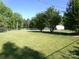 Expansive backyard featuring lush green grass, trees, and a white storage building at 44716 Gold Branch Rd, Richfield, NC 28137