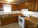 Kitchen featuring ample wood cabinetry, stainless steel sink and white appliances at 44716 Gold Branch Rd, Richfield, NC 28137