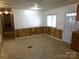 A living room with wood paneling, a window, white door, and light floors at 44716 Gold Branch Rd, Richfield, NC 28137