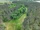 An aerial view showcases the expansive property's lush greenery and a winding path through the trees at 4815 Nc 109 Hwy, Wadesboro, NC 28170