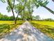 Long gravel driveway leading to a house surrounded by lush green lawns and mature trees at 4815 Nc 109 Hwy, Wadesboro, NC 28170