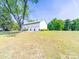 Side view of large, white garage featuring three bays on a sprawling green lawn at 4815 Nc 109 Hwy, Wadesboro, NC 28170