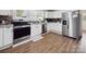 Bright kitchen features stainless steel appliances, white cabinets and warm wood-look flooring at 4815 Nc 109 Hwy, Wadesboro, NC 28170