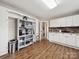 Well-lit kitchen features modern white cabinetry, brick backsplash, open shelving, and modern flooring at 4815 Nc 109 Hwy, Wadesboro, NC 28170