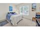 Charming bedroom with a cozy blue comforter, accent pillows, and a sunlit window at 54053 Flycatchers Ct, Fort Mill, SC 29707