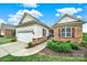 Charming home exterior with stone accents, a two-car garage, and landscaped yard at 54053 Flycatchers Ct, Fort Mill, SC 29707