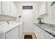 Well-organized laundry room featuring a washer, dryer, utility sink, and ample cabinet space at 54053 Flycatchers Ct, Fort Mill, SC 29707