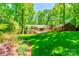 Mature trees and lush landscaping surround this home's outdoor kitchen and patio area, perfect for entertaining at 5719 Doncaster Dr, Charlotte, NC 28211