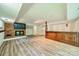 Finished basement with brick fireplace, TV, built in bar and new flooring creates an ideal entertainment space at 5719 Doncaster Dr, Charlotte, NC 28211