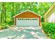 A detached garage with a white garage door and plenty of parking space, surrounded by trees at 5719 Doncaster Dr, Charlotte, NC 28211