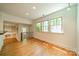 Light-filled living room with wood floors, neutral walls, and large windows overlooking the backyard at 5719 Doncaster Dr, Charlotte, NC 28211