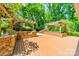 An outdoor kitchen with stone accents, a grill, sink, and a deck area next to a pergola-covered hot tub at 5719 Doncaster Dr, Charlotte, NC 28211
