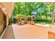 Outdoor kitchen with stainless steel grill, stone countertops, and a spacious wooden deck, perfect for entertaining guests at 5719 Doncaster Dr, Charlotte, NC 28211