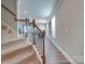 Carpeted staircase with dark wood railings and a view into the living and dining area at 574 Altamonte Dr, Clover, SC 29710