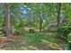 Serene backyard with a screened porch, waterfront views, mature trees, and lush landscaping for ultimate privacy at 5915 Mammoth Rd, Charlotte, NC 28270
