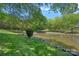 Beautiful view of pond surrounded by lush greenery and mature trees at 5915 Mammoth Rd, Charlotte, NC 28270