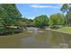 Community pond featuring a beautiful fountain surrounded by lush landscaping and mature trees in a park-like setting at 5915 Mammoth Rd, Charlotte, NC 28270