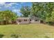 Expansive backyard featuring a well-maintained lawn, wooden deck, mature trees, and full fence at 6007 Charing Pl, Charlotte, NC 28211