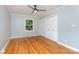 Spacious bedroom featuring hardwood floors, ceiling fan, and closet for ample storage space at 6007 Charing Pl, Charlotte, NC 28211