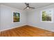 Bright bedroom with hardwood floors, neutral walls, ceiling fan and two windows offering lots of natural light at 6007 Charing Pl, Charlotte, NC 28211