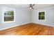 Bright bedroom with hardwood floors, ceiling fan, and two windows offering lots of natural light at 6007 Charing Pl, Charlotte, NC 28211