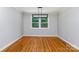 Elegant dining room with hardwood floors, a modern light fixture, and a large window overlooking the backyard at 6007 Charing Pl, Charlotte, NC 28211