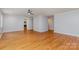 Open-concept living area showcasing hardwood floors, neutral walls, a ceiling fan, and easy access to the kitchen at 6007 Charing Pl, Charlotte, NC 28211