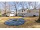 Large backyard featuring a fire pit with gravel surround and a manicured lawn at 6706 Queensberry Dr, Charlotte, NC 28226