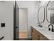 Modern bathroom featuring dual sink vanity with modern black fixtures, wood accents, and black tile at 6706 Queensberry Dr, Charlotte, NC 28226