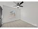 Bright bedroom with carpet, ceiling fan, window, and dark-colored door at 6706 Queensberry Dr, Charlotte, NC 28226