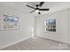 Bright bedroom featuring carpet, a ceiling fan, and two large windows at 6706 Queensberry Dr, Charlotte, NC 28226