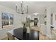Bright dining room with a black table, modern chandelier, and a view into the kitchen at 6706 Queensberry Dr, Charlotte, NC 28226