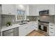 Bright kitchen with stainless steel appliances, grey backsplash, and white cabinetry at 6706 Queensberry Dr, Charlotte, NC 28226