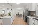 Bright kitchen featuring stainless appliances, a quartz island, and open sight lines to the dining and living rooms at 6706 Queensberry Dr, Charlotte, NC 28226