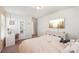 Bright bedroom with a TV, a white vanity, and lots of natural light from a large window at 6878 Spring Peeper Ln, Lancaster, SC 29720