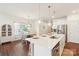 Bright kitchen with white cabinets, stainless steel appliances, and a large island adjacent to the dining area at 6878 Spring Peeper Ln, Lancaster, SC 29720
