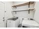 Modern laundry room with shelving, washer, dryer and a door leading outside at 6878 Spring Peeper Ln, Lancaster, SC 29720
