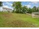Expansive backyard with a gentle slope, bordered by a wooden fence, offering ample space and privacy at 7031 Woodbridge Valley Cir, Charlotte, NC 28227