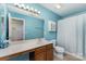 Bathroom features a single sink vanity, large mirror, and bathtub with shower at 7031 Woodbridge Valley Cir, Charlotte, NC 28227