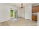 Well-lit dining area with neutral tile, a sliding glass door, and access to the kitchen area at 7031 Woodbridge Valley Cir, Charlotte, NC 28227