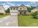 Charming two-story home featuring a spacious lawn, a two-car garage, and a welcoming front porch at 7031 Woodbridge Valley Cir, Charlotte, NC 28227
