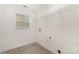 Neutral laundry room with shelving, tiled floors, and window providing natural light at 7031 Woodbridge Valley Cir, Charlotte, NC 28227