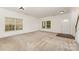 Well-lit living room features plush carpeting and large windows, perfect for entertaining or relaxing at 7031 Woodbridge Valley Cir, Charlotte, NC 28227