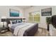 Stylishly furnished main bedroom with large window providing ample light and calming wall art at 7031 Woodbridge Valley Cir, Charlotte, NC 28227