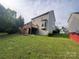 Spacious backyard with a wooden deck, lush green lawn, and mature trees at 715 Larimer Ln, Charlotte, NC 28262